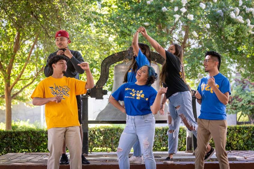 Students making fun poses together on campus.